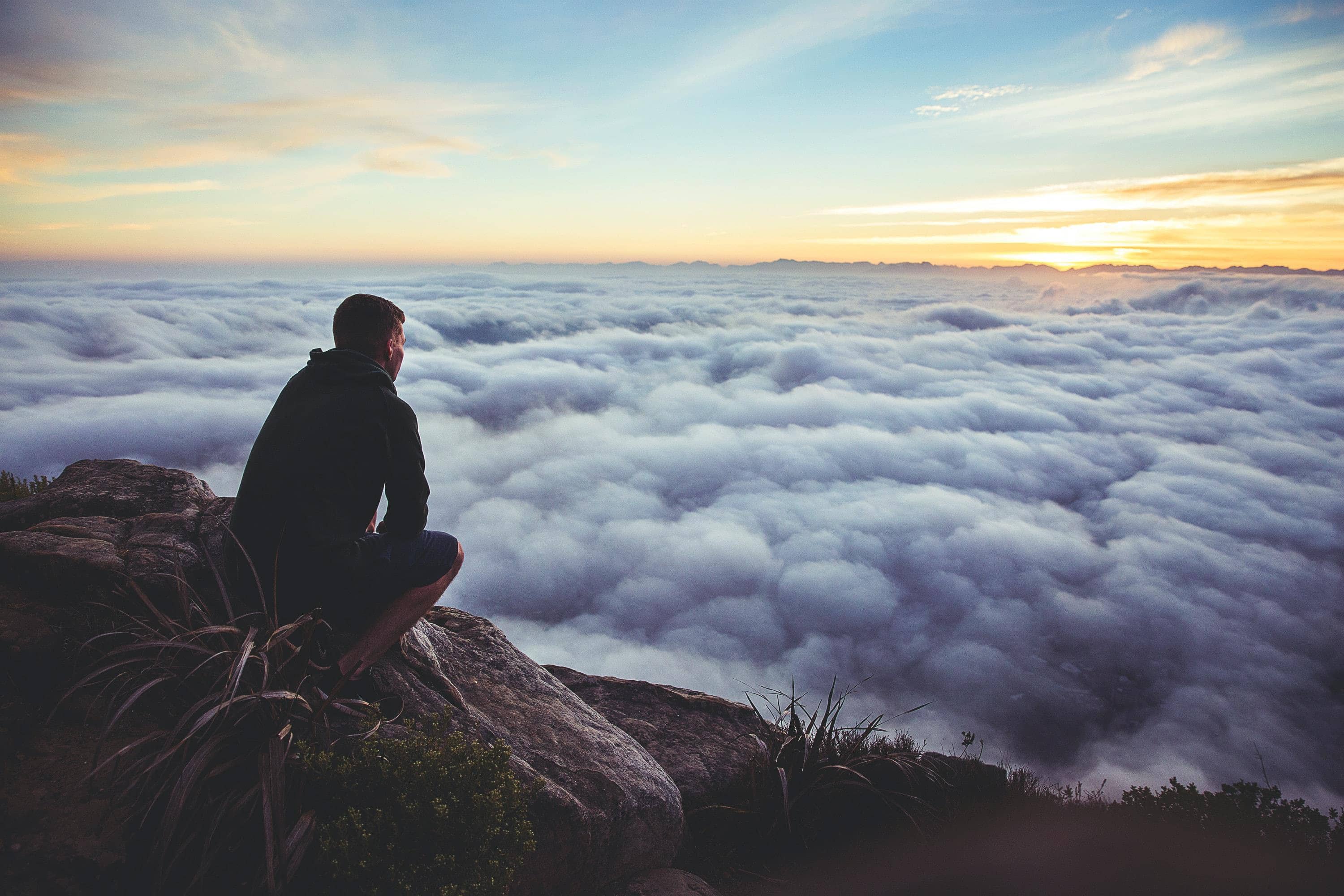 WHY Report Header Image - Man on a mountain overlooking clouds